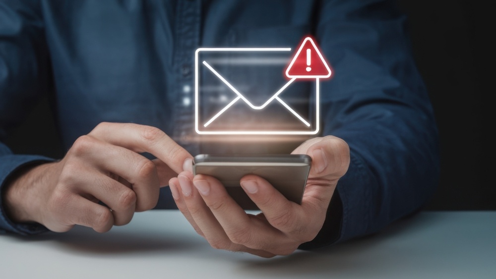 Man on phone looking at email alert